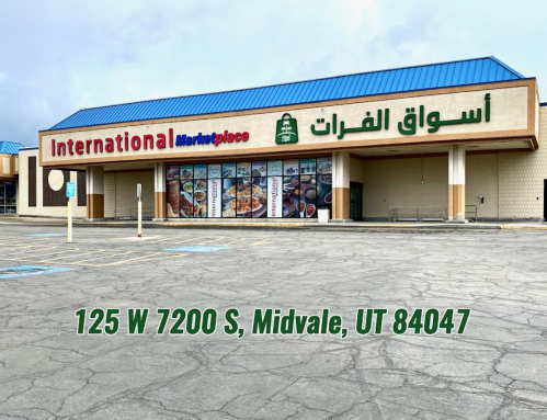 Exterior of International Marketplace in Midvale, UT, featuring signage in English and Arabic. Address displayed below.
