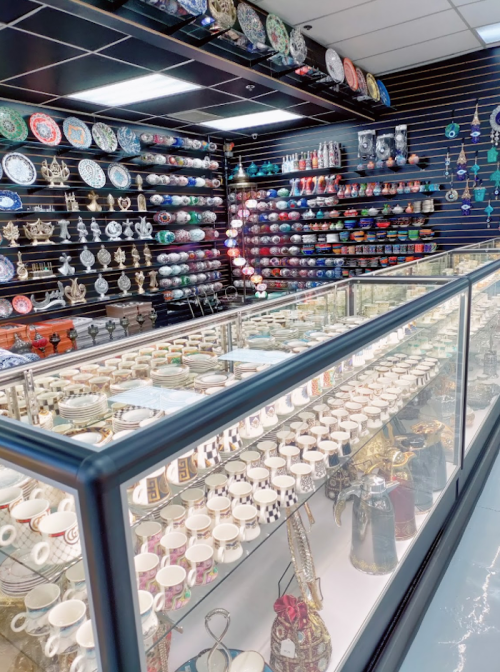 A display of colorful ceramics and decorative items in a shop, with shelves filled with various plates and cups.