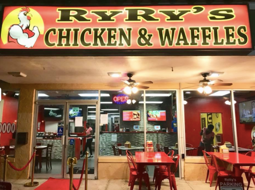 Exterior of Ryry's Chicken & Waffles restaurant, featuring a bright sign and outdoor seating area.