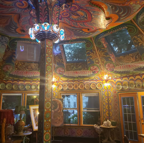 Colorful, intricately painted interior with ornate designs, large windows, and decorative lighting fixtures.