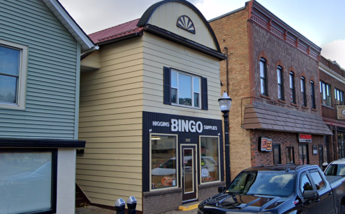 A two-story building with a sign reading "Higgins Bingo Supplies" on the ground floor, located in a small town.
