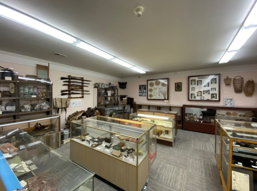A museum interior featuring display cases with various historical artifacts and exhibits on the walls.