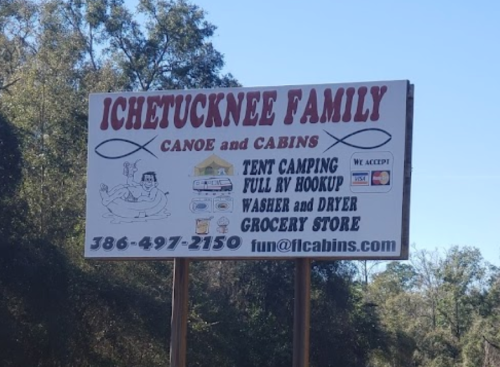 Sign for Ichetucknee Family Canoe and Cabins, featuring camping options, amenities, and contact information.