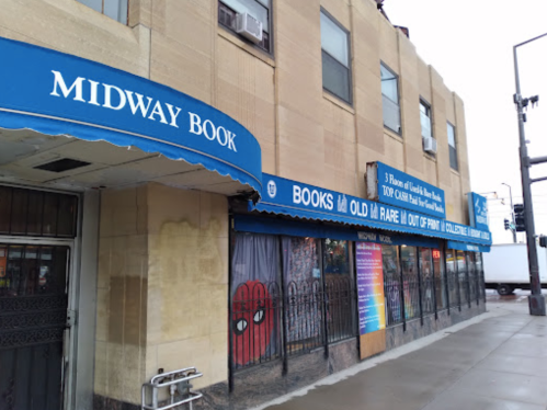 Exterior of Midway Book store with blue awning, colorful window displays, and a Spiderman mural.