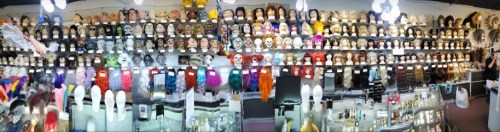 A colorful display of various wigs and masks arranged on shelves in a store.