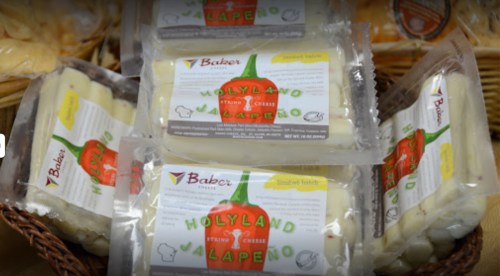 Packages of Holyland Jalapeño cheese displayed in a basket, featuring a red pepper graphic on the label.