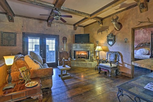 Cozy living room with rustic decor, a fireplace, wooden beams, and comfortable seating.