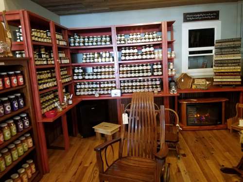 A cozy shop interior with shelves filled with jars and candles, wooden furniture, and a warm atmosphere.