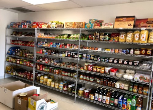 A well-organized pantry with shelves filled with various jars, cans, and boxes of food items.