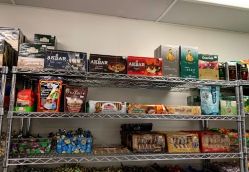 Shelves filled with various brands of tea, cookies, and snacks in colorful packaging.