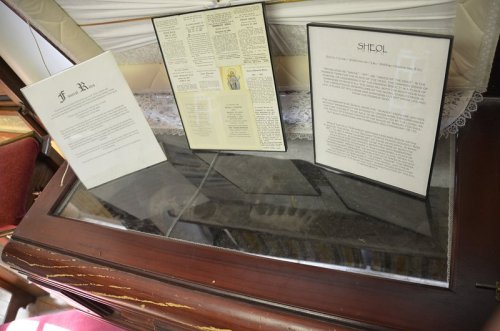 Three framed documents displayed on a wooden surface, with a lace cloth in the background.