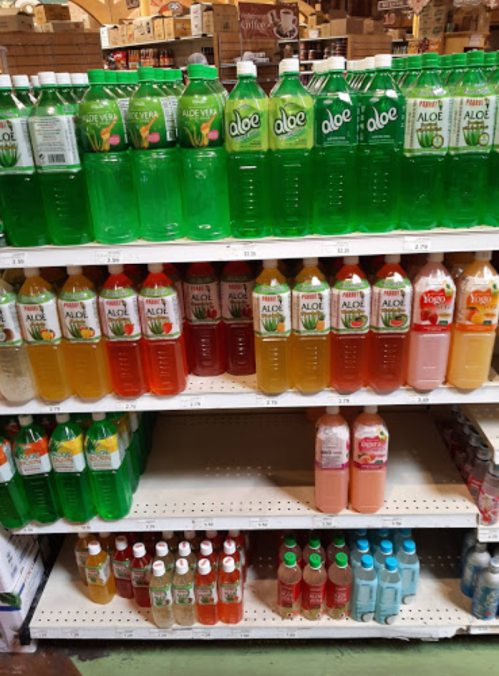 Shelves stocked with various bottles of aloe vera drinks in different colors and flavors.