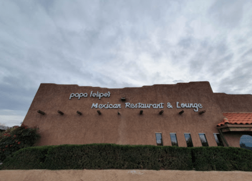 Sign for Papa Felipe's Mexican Restaurant & Lounge on a stucco building with a cloudy sky above.