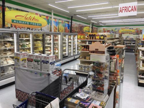 A grocery store aisle featuring frozen foods, shelves of products, and a sign reading "African" above.