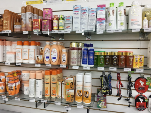 A variety of hair and skin care products displayed on shelves in a store, including shampoos, conditioners, and oils.