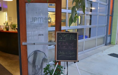 A restaurant entrance with a chalkboard sign displaying "A Taste of Southern Mexico" and the name "Gomal."