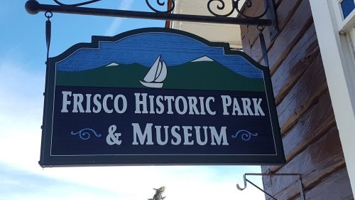 Sign for Frisco Historic Park & Museum featuring a sailboat and mountains in the background.