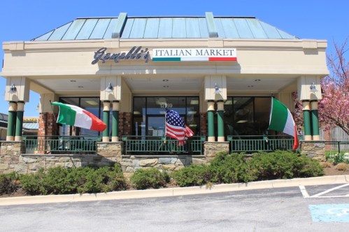 Exterior of Ganelli's Italian Market with Italian and American flags displayed outside on a sunny day.