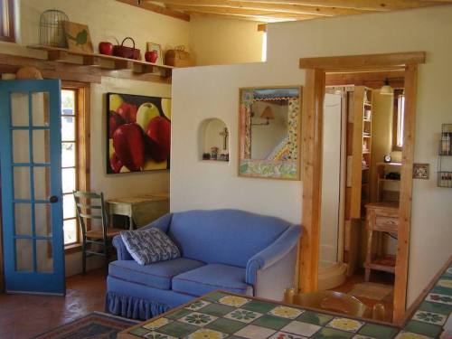 Cozy interior of a home featuring a blue sofa, colorful artwork, and wooden accents in a bright, inviting space.