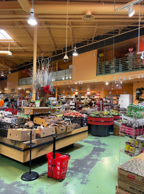 A vibrant grocery store interior with colorful produce displays, shopping carts, and a warm, inviting atmosphere.