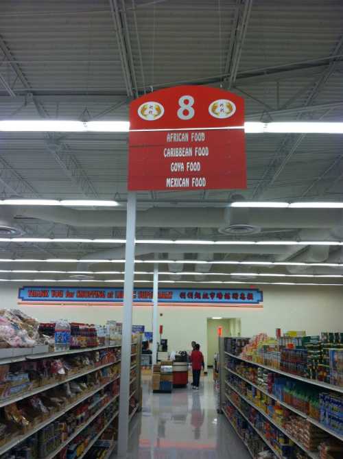 A store aisle sign indicating sections for African, Caribbean, Goya, and Mexican food.