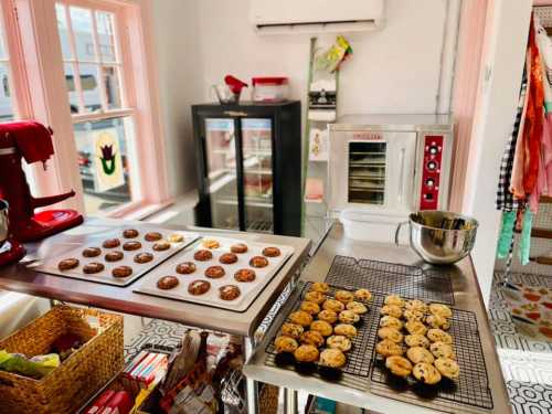 A bright kitchen with freshly baked cookies cooling on racks and a mixer on the counter.