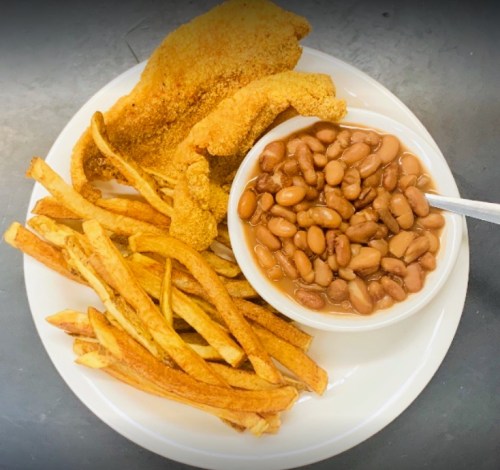 A plate with golden fried fish, crispy fries, and a bowl of baked beans.