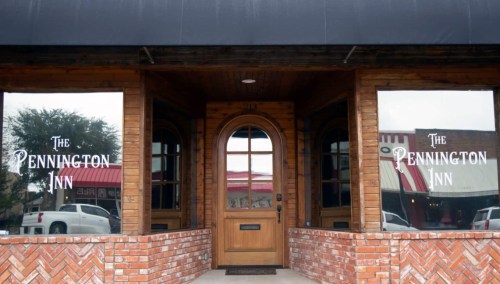 Front entrance of The Pennington Inn, featuring wooden doors and large windows with the inn's name displayed.