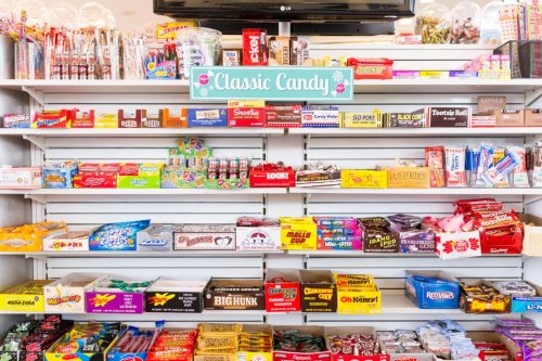 A colorful display of classic candies on shelves, featuring various brands and types of sweets.