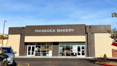 Exterior of Pangaea Bakery, featuring large windows and a modern design against a clear blue sky.