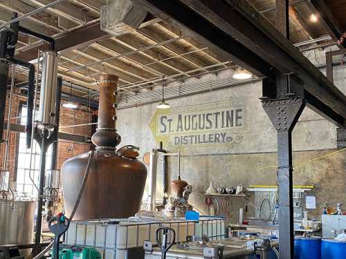 Interior of St. Augustine Distillery featuring large copper stills and industrial decor.