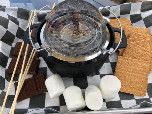 A s'mores kit with graham crackers, chocolate, marshmallows, and a small grill for toasting.