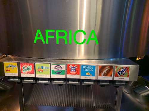 A beverage dispenser labeled "AFRICA" with various drink options displayed on the front.