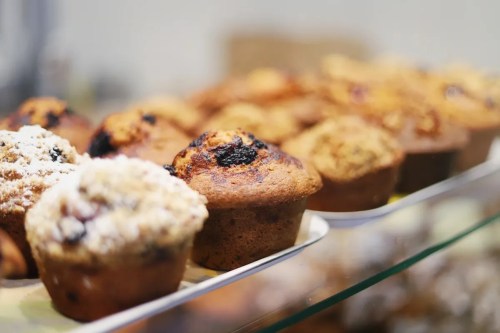 A display of freshly baked muffins, featuring various flavors and toppings, arranged on a tray.