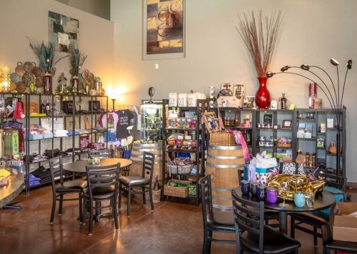 A cozy shop interior with shelves of gifts and decor, tables, and decorative items, creating a warm atmosphere.