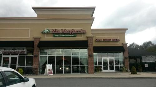Exterior view of a pizza restaurant with large windows and a sign reading "Mia Margarita" and "Coal Fired Pizza."