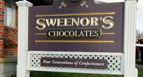 Sign for Sweenor's Chocolates, featuring the text "Four Generations of Confectioners" below the main logo.
