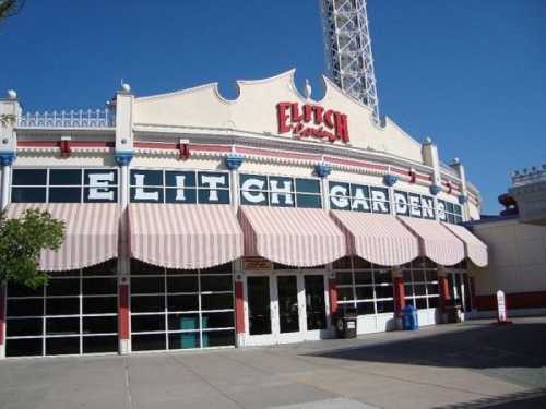 Entrance of Elitch Gardens amusement park, featuring a colorful facade and large windows under striped awnings.