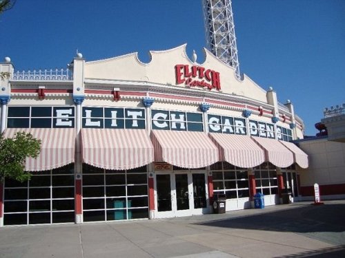 Front view of Elitch Gardens amusement park entrance with striped awnings and a clear blue sky.