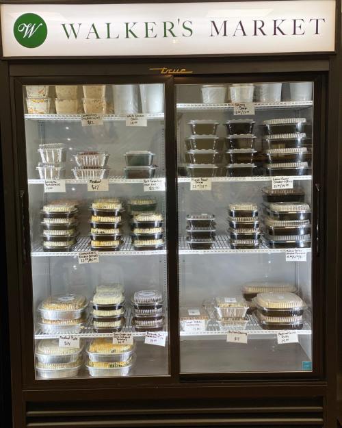 A display case at Walker's Market filled with various packaged food items and labeled containers.
