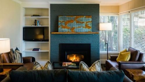 Cozy living room with a fireplace, modern decor, and large windows letting in natural light.