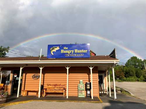 A restaurant called "the Hungry Hunter" with a rainbow in the background and a clear sky above.