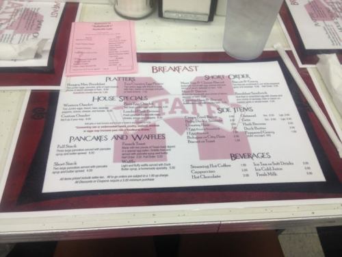 A restaurant menu featuring breakfast items, platters, house specials, sides, and beverages, with a prominent logo.
