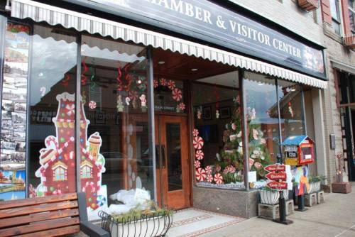 A festive visitor center decorated with holiday-themed window displays and candy cane motifs.