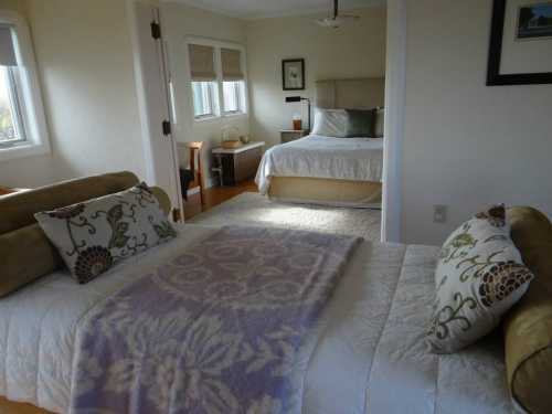 Cozy bedroom with a double bed and a single bed, featuring soft pillows and a light-colored blanket.