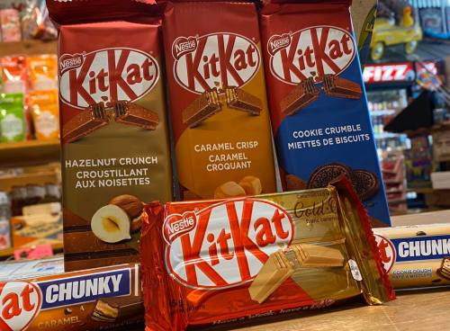 Various Kit Kat chocolate bars displayed, including Hazelnut Crunch, Caramel Crisp, and Cookie Crumble flavors.