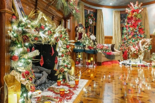 A beautifully decorated room for the holidays, featuring a festive tree, garlands, and a cozy fireplace.