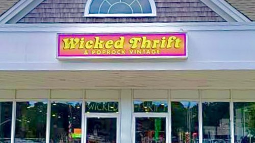 Sign for "Wicked Thrift & Poprock Vintage" above a storefront with large windows.