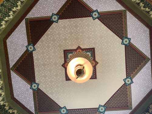 Ornate ceiling design featuring geometric patterns and a central light fixture.