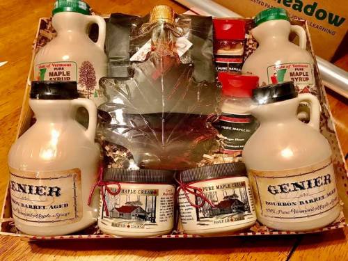 A gift basket featuring various maple syrup products, including bottles, cream, and a decorative maple leaf.